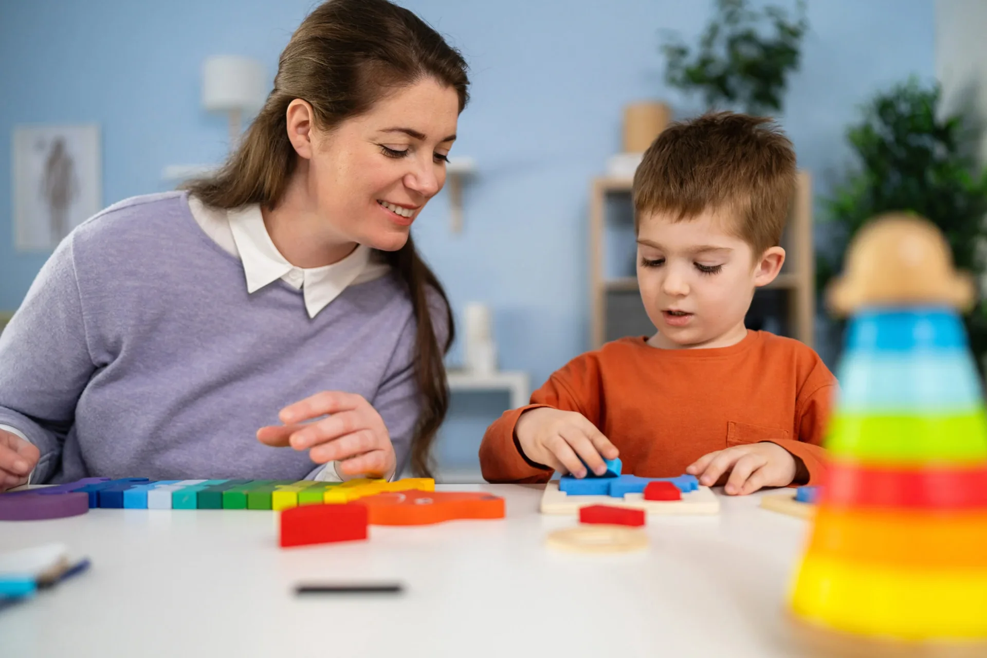 Female pediatrician examining the boy's creative skills and level of development, during an annual medical visit